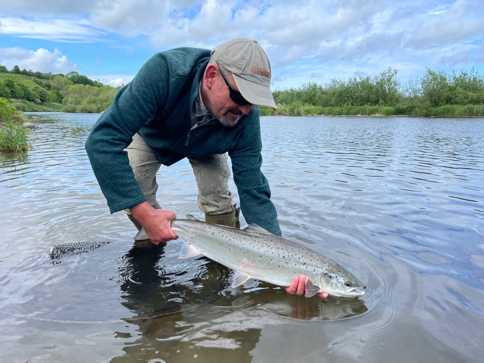 A man holding a salmon in the water