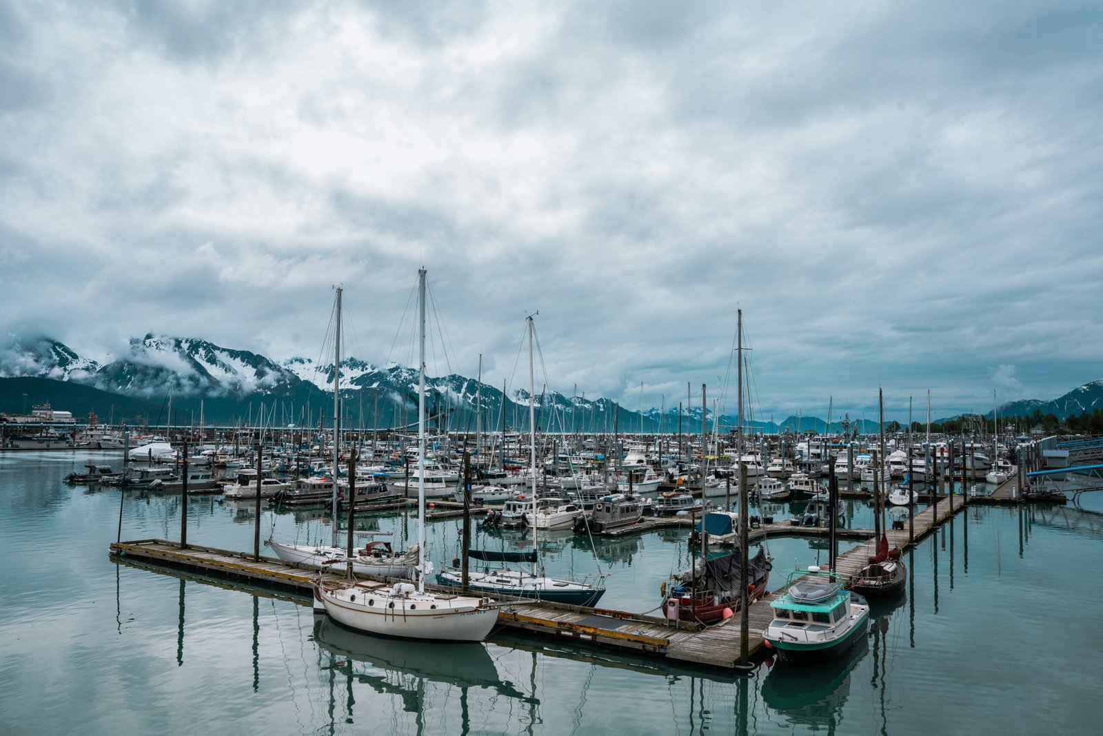 boats on dock under cloudy sky