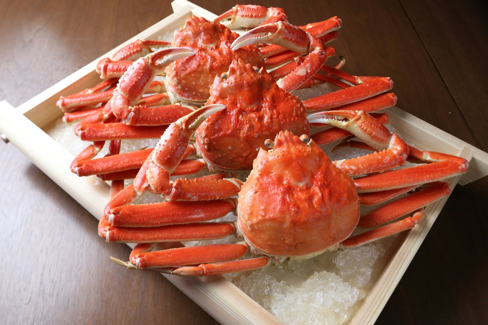 A tray of cooked alaskan king crabs on a table